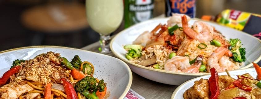 Three plates of thai food on a table