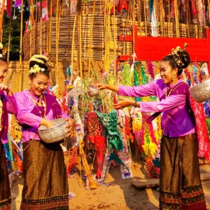 Two thai ladies celebrating the new year in purple and brown traditional dresses